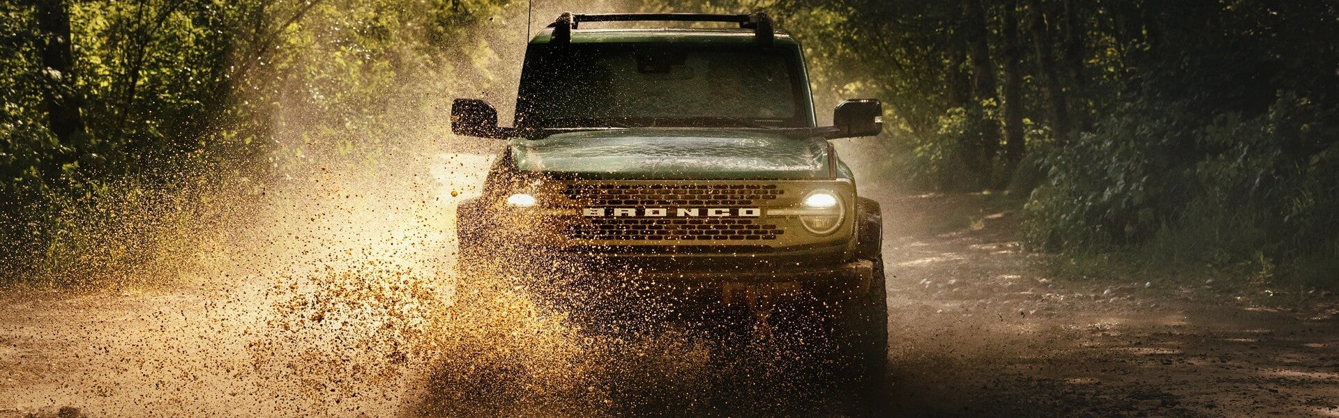 Ford Bronco driving through mud