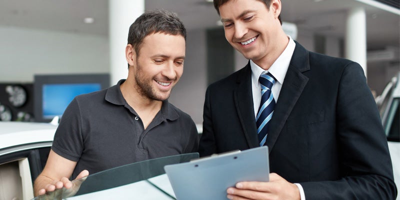 Atchinson Ford in Belleville MI sales rep going over leasing paperwork with a customer